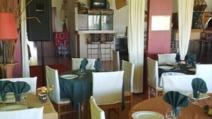 A dining area with tables set for two, chairs, and a buffet counter in the background. - Quinta do Valão (Alcobaça)
