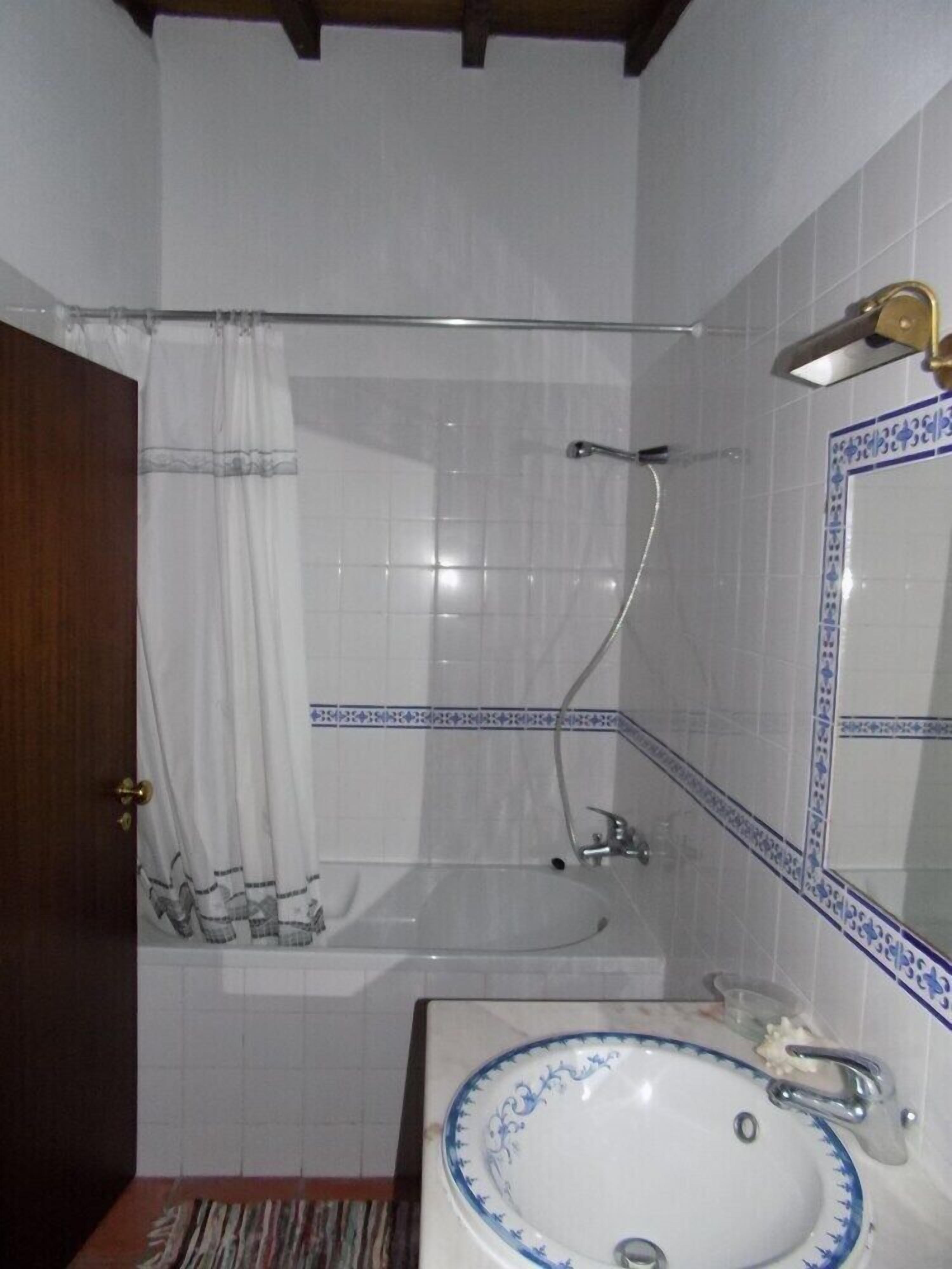 Un bany amb dutxa, un lavabo i un mirall.