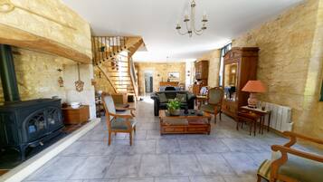 Télévision, cheminée, lecteur de DVD, livres