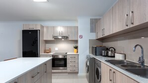 Una cocina moderna con armarios de madera, electrodomésticos de acero inoxidable y horno empotrado.