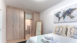 Un dormitorio moderno con una cama grande, un armario y un espejo.