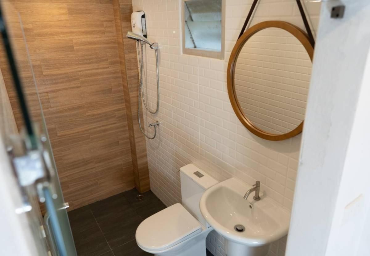 A bathroom with a toilet, sink, and shower.