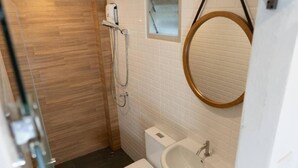 A bathroom with a toilet, sink, and shower.