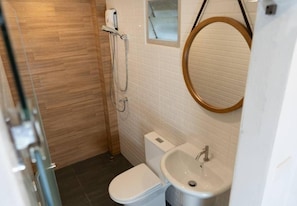 A bathroom with a toilet, sink, and shower. - Malades House (Bangkok)