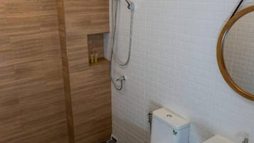 A modern bathroom with a wooden shower enclosure, a white toilet, and a sink with a mirror.