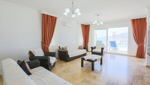 Ein geräumiges Wohnzimmer mit einer Sofagarnitur, einem Couchtisch und einem Kronleuchter.