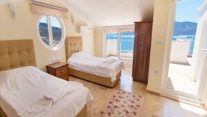 Ein Schlafzimmer mit zwei Betten, einem Fenster, einem Balkon und Meerblick.