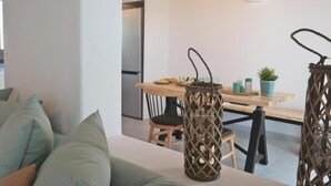 A modern kitchen with a dining table, chairs, and a hanging light fixture. - Villa Lantana with Private Swimming Pool - Salinus Naxian Villas (Naxos)