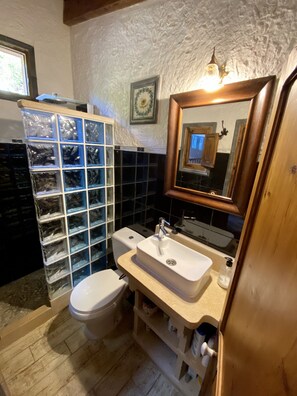A bathroom with a toilet, sink, and storage shelves. - Finca Ses Fontanelles (Andraitx)