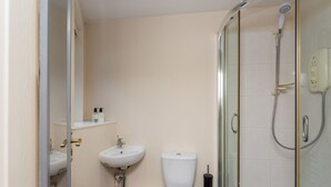Een badkamer met toilet, wastafel en douche.