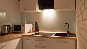 Deluxe Apartment | Private kitchen | Fridge, electric kettle, cookware/dishes/utensils, dining tables