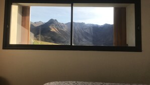 Une chambre dotée d’une grande fenêtre donnant sur les montagnes.