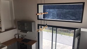 Une cuisine moderne dotée d’une grande fenêtre, d’un coin repas et offrant une vue sur l’extérieur.