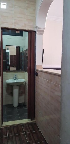 A bathroom with a sink, mirror, and tiled floor. - Alaamira Furnished Apartments (Chiyah)