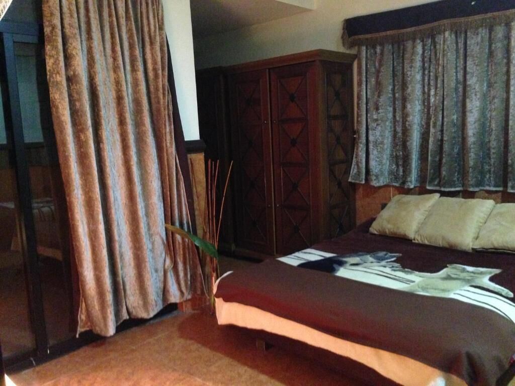 A bedroom with a bed, a wardrobe, and curtains.