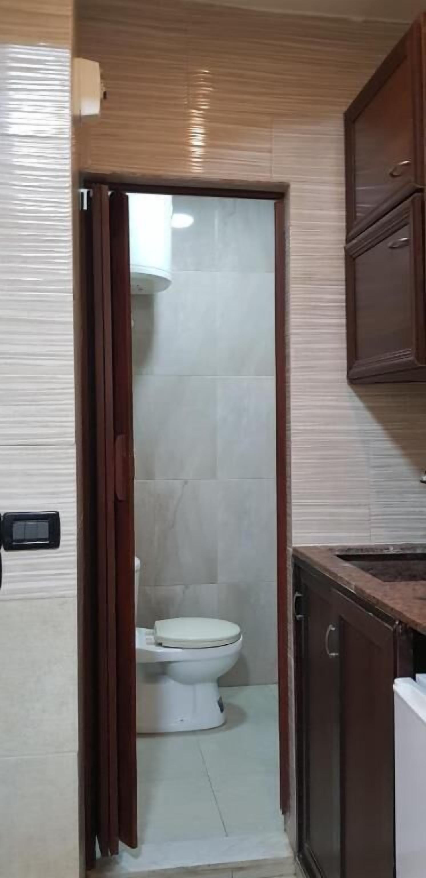 A bathroom with a toilet, a shower, and a sink.