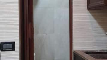 A bathroom with a toilet, a shower, and a sink.