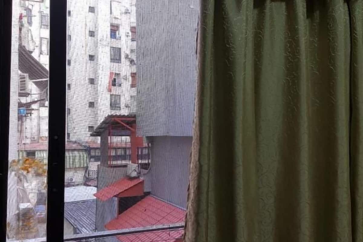A room with a large window overlooking a building with multiple floors and balconies.