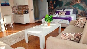 A modern living room with a white coffee table, a sofa, and a bed with a purple and white color scheme. - Medellin Apart Hotel Istanbul (Istanbul)