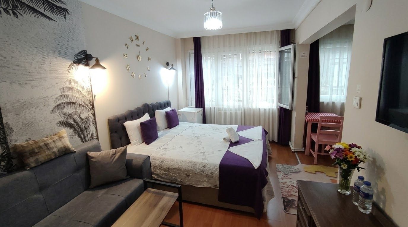 Een slaapkamer met een bed, een bank, een bureau en een stoel.