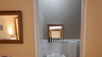 Un baño con lavabo, inodoro y un armario de madera con cajones.
