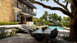 A modern house with a stone facade, a pool, and outdoor furniture. - Le Thallo (Cape Town)