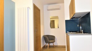 A compact kitchen with a built-in stove, a small sink, and a mirror on the wall. - Residenza Montegrappa (Peschici)