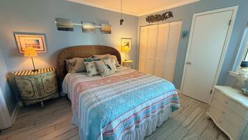 A bedroom with a bed, bedside tables, a wardrobe, and a ceiling fan.