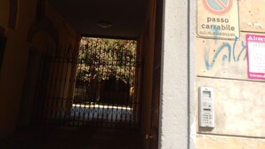 An entrance with a metal gate, a no parking sign, and a security keypad on the wall. - Kibilù - Viale Bligny OSV (Milan)
