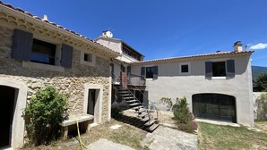 Una casa de piedra de dos pisos con una escalera de piedra que lleva a un balcón.