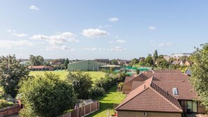 A residential area with multiple houses, a green field, and a clear sky. - West Bridgford Classy 2bed Flat (Nottingham)