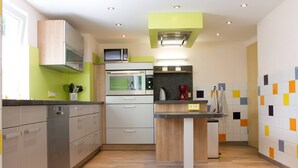 Una cocina moderna con electrodomésticos de acero inoxidable, un microondas y una cafetera.