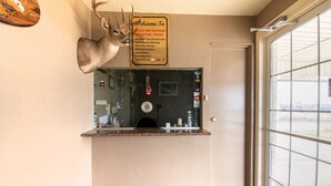 A reception area with a deer head decoration, a welcome sign, a glass display case, and a view of the outside through a window. - OYO Hotel Decatur TX Hwy 287 Northwest (Decatur)