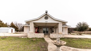 A building with a brick facade, a large entrance, and a number "1350" above the door. - OYO Hotel Decatur TX Hwy 287 Northwest (Decatur)