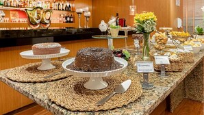 Montaje de bufé con diversos postres y una barra en el fondo.
