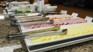 A buffet with various food items and serving utensils.