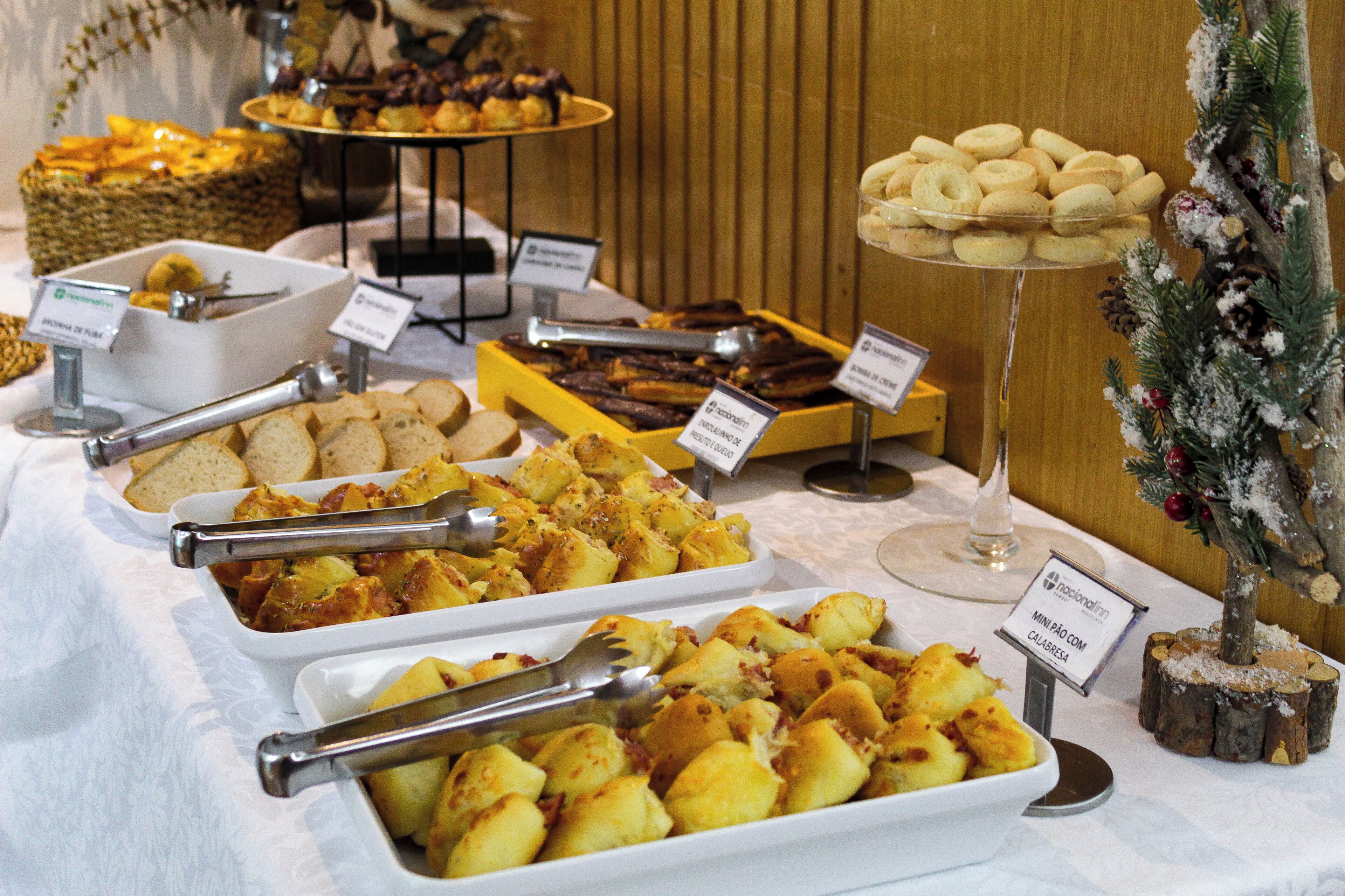 Un buffet con diversi piatti, tra cui pane, patate e dolci.