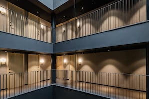 A multi-level interior with a central open space and balconies. - Raval House (Barcelona)
