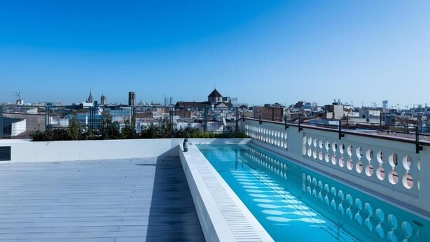 Una piscina en la azotea con vistas panorámicas al paisaje urbano.