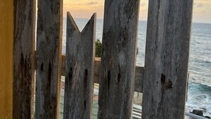 Une clôture en bois ornée d’une étoile, qui mène à un point de vue sur l’océan.