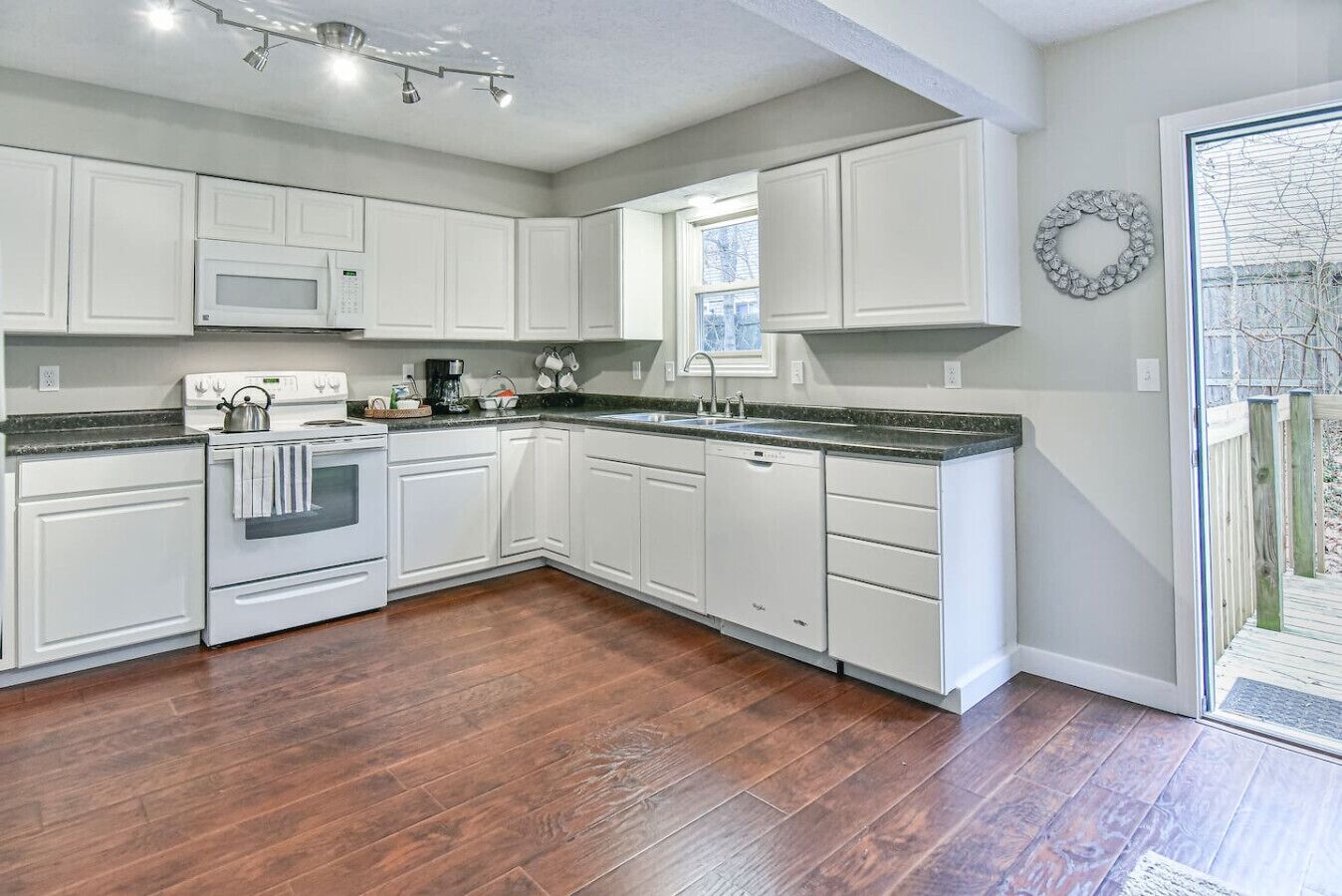 A kitchen with white cabinetry, a microwave, stove, and a dishwasher.