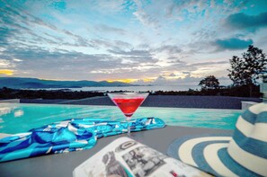 A poolside view with a clear sky, a martini glass, and a striped towel. - Samui Sunsets Luxury Villas (Koh Samui)