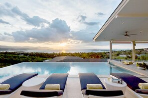 A poolside lounge with sun loungers and a view of the sunset over the ocean. - Samui Sunsets Luxury Villas (Koh Samui)