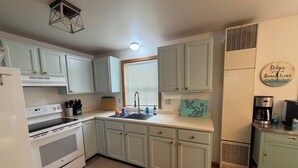 A kitchen with light blue cabinets, a white refrigerator, a stove, a sink, and a coffee maker. - Perfect Family Escape! Walk to everything and relax. It’s all here for you  (York)