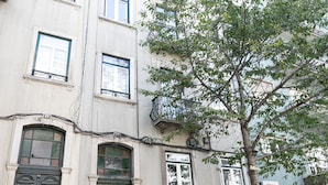 A building with multiple windows and a green door. - Bhuiyan Family Host (Lisbon)