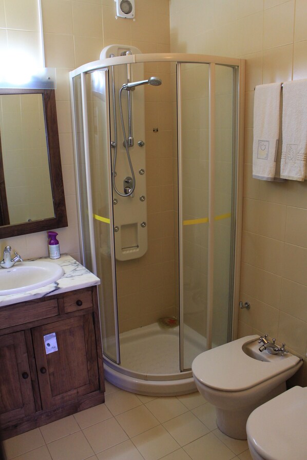 Une salle de bain avec une douche à parois de verre, un lavabo et des toilettes.