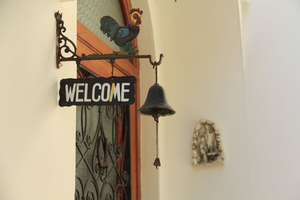 A 'WELCOME' sign with a bell and a rooster decoration. - Casa Augusto (Capri)