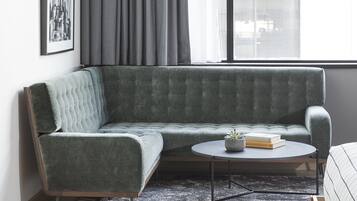 A modern living room with a grey sofa, a round coffee table, and a small potted plant.