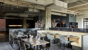 A modern restaurant with a mix of booth and table seating, a bar area, and a view of the cityscape. - Fitler Club (Philadelphia)