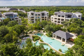 A resort with multiple buildings, a swimming pool, and lush greenery. - Fairmont Heritage Place Mayakoba (Playa del Carmen)